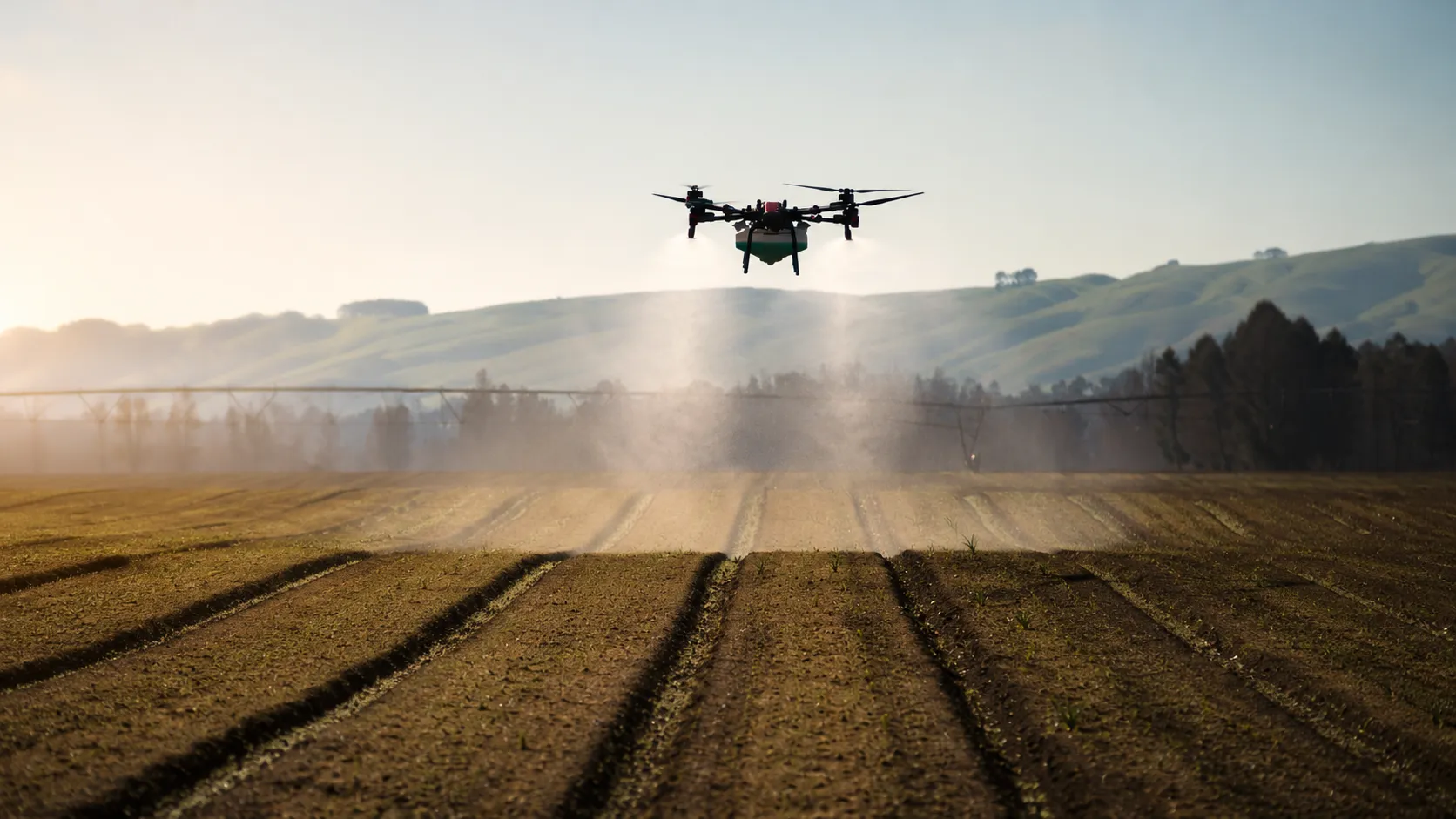 A Vantage spray drone applying product head-on low over a cultivated field at sunrise