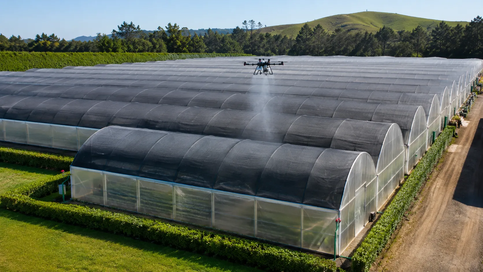 A drone applying shade coating along the inside of a greenhouse tunnel