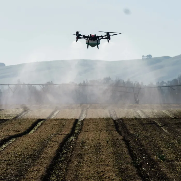 A spray drone applying product evenly across a cultivated paddock